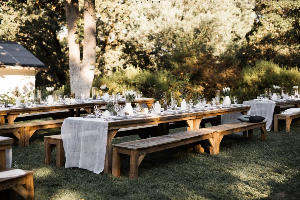 picnic style wedding dinner with long wooden tables