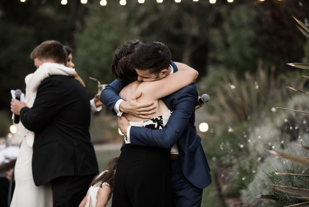 groom hugging his sister during their wedding speeches