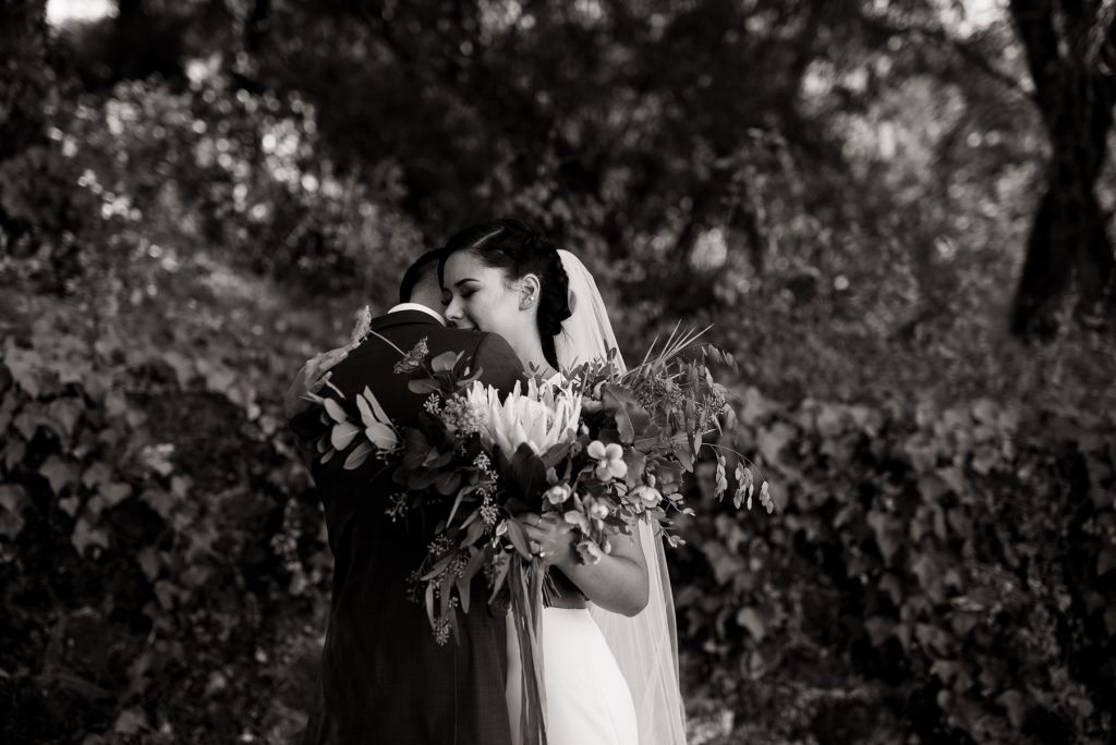intimate hug between bride and groom in black and white