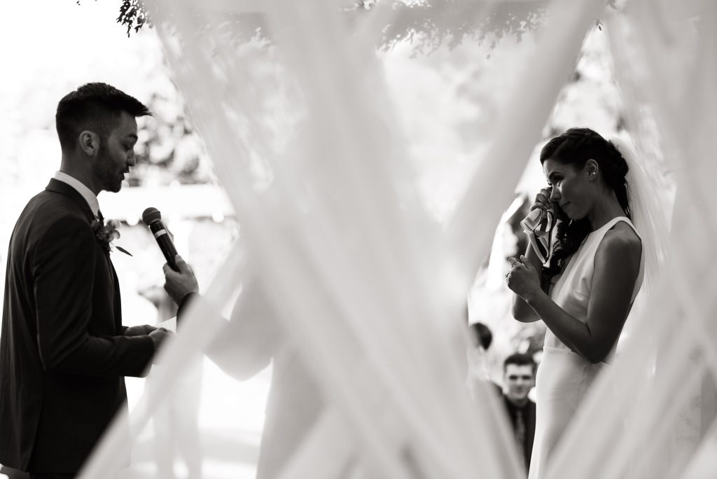 bride wiping happy tears during wedding vows
